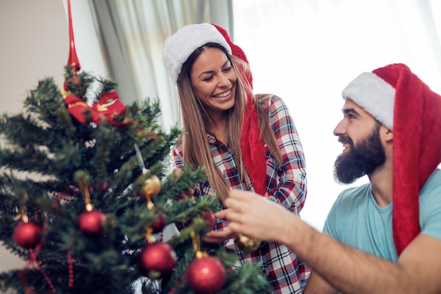 Young couple decorating a Christmas tree