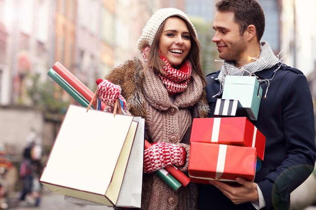 Photo young couple doing christmas shopping in the city