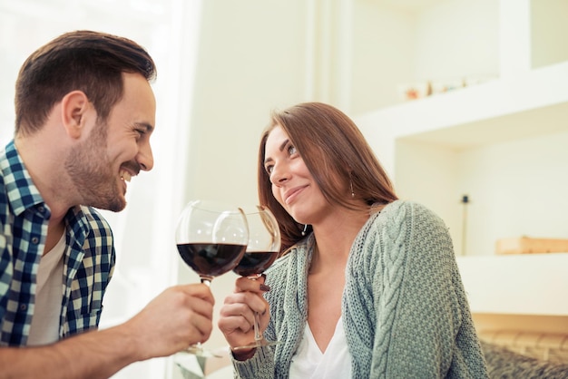 Young couple drinking red wine and smiling