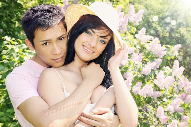 Young couple in embrace near the lilacs