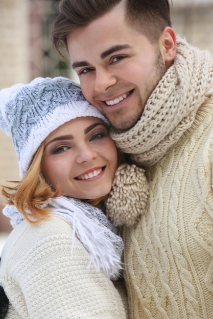 Young couple embracing outdoors in winter close up