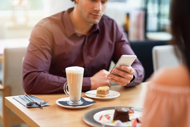 young Couple Enjoying Coffee And Cake In Cafe