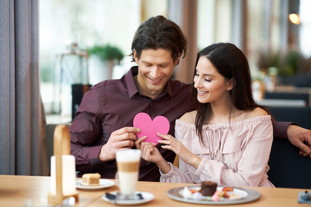 young Couple Enjoying Coffee And Cake In Cafe