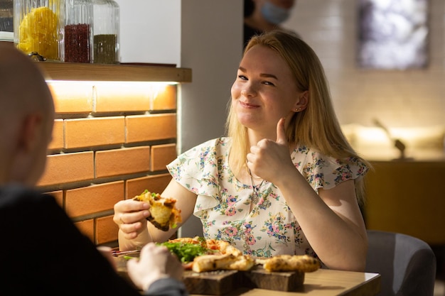 Young couple enjoying pizza while sitting in the pizzeria