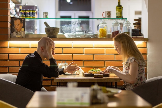 Young couple enjoying pizza while sitting in the pizzeria