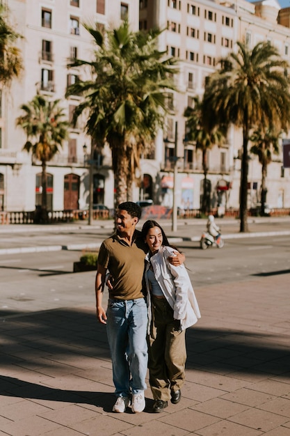 Young couple enjoying a sunny stroll along Barcelona palmlined promenade