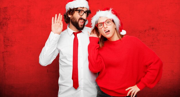 Photo young couple expressing christmas concept. couple and background in different layers