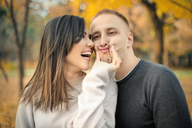 Young couple fooling around while walking in nature in autumn