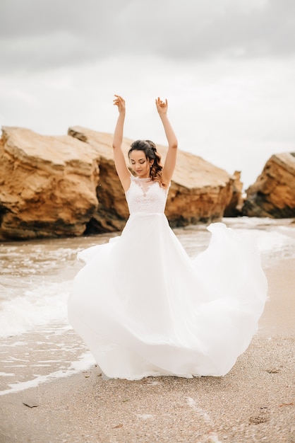 Young couple groom with the bride on a sandy beach at a wedding walk