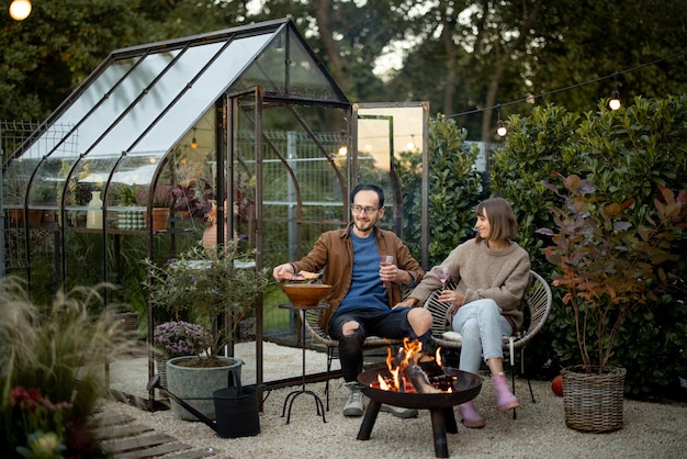 Young couple have a dinner by the fire at backyard