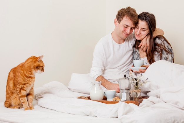 Young couple having breakfast in bed