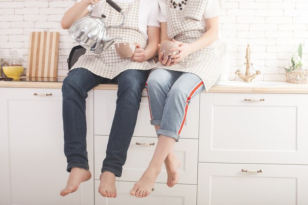 Young couple having fun at the kitchen. Attractive man and beautiful woman on kitchen background.