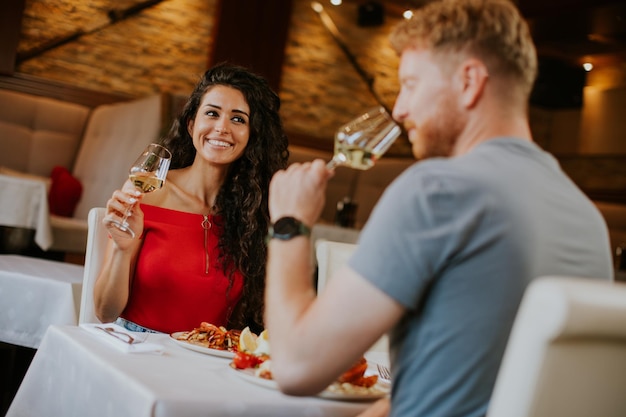 Young couple having lunch with white wine in the restaurant