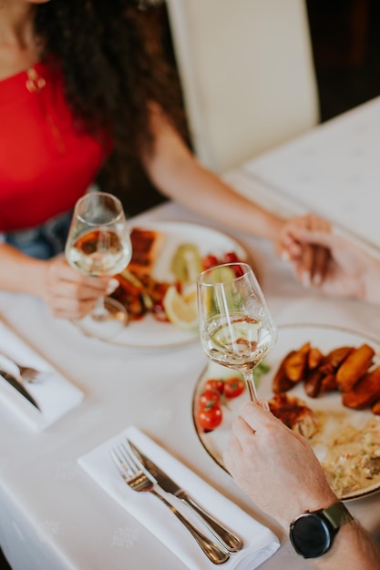 Young couple having lunch with white wine in the restaurant