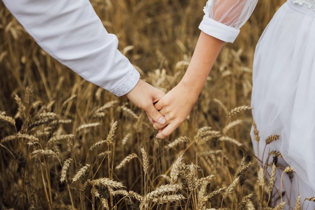 Young couple holding hands in the field Closeup