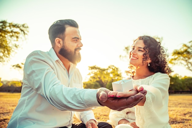 Young couple holding hands in a park at sunset