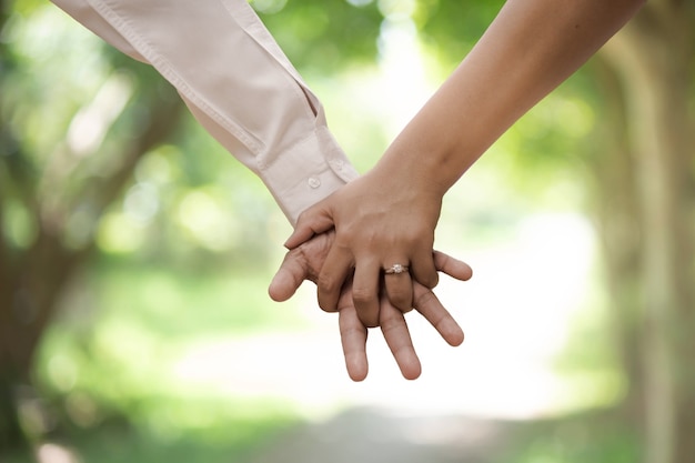 a young couple holding hands in the park thailand