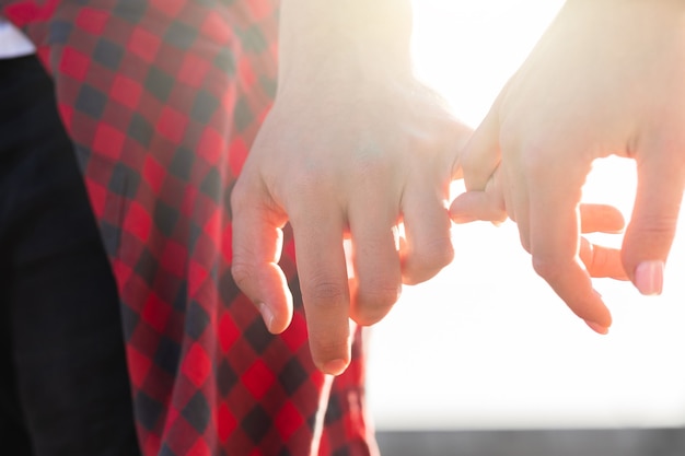 Photo young couple holding hands with a pinky grip