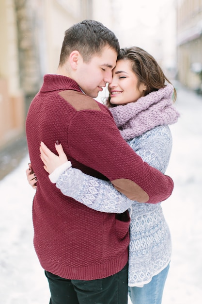 Young couple hugging and kissing in the city center in winter. Family, love,  . Lviv, Ukraine