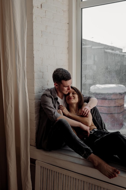 Young couple hugging and kissing at home in loft style interior Romantic couple of lovers