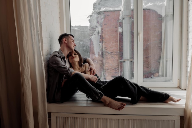 Young couple hugging and kissing at home in loft style interior Romantic couple of lovers