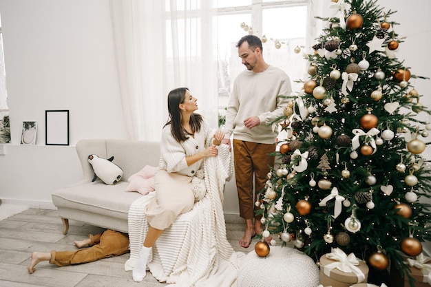 Young couple hugging near christmas tree at home