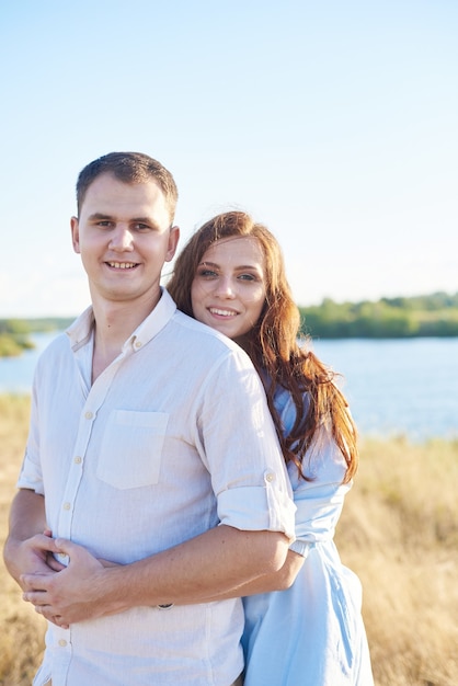 A young couple hugs in a wheat field, laughs and enjoy life. The concept of love and correct non-abusive relationships.