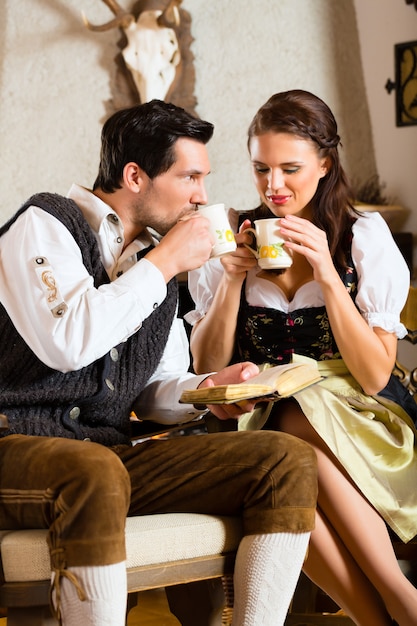 Young couple in a hunter's cabin drinking tea