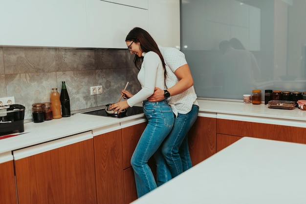 A young couple is cooking together in the kitchen. The couple spending time in the kitchen