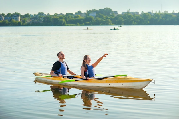 A young couple is kayaking on a pond water tourism active recreation