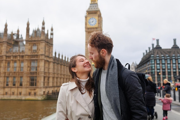 Young couple is kissing against the background of the Big Ben tower in London