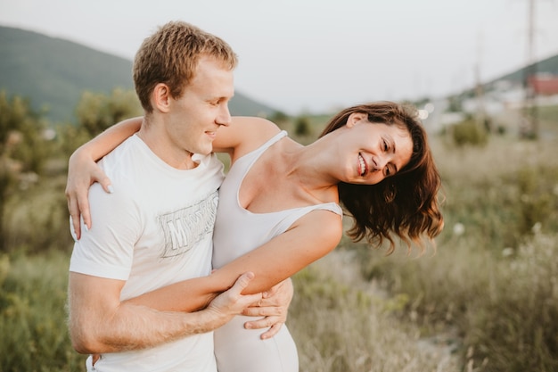 Young couple kissing and huging outdoors in summer.