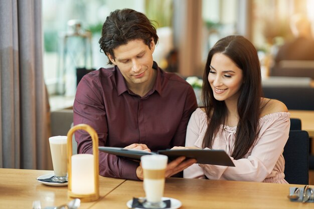 young Couple looking at menu In Cafe