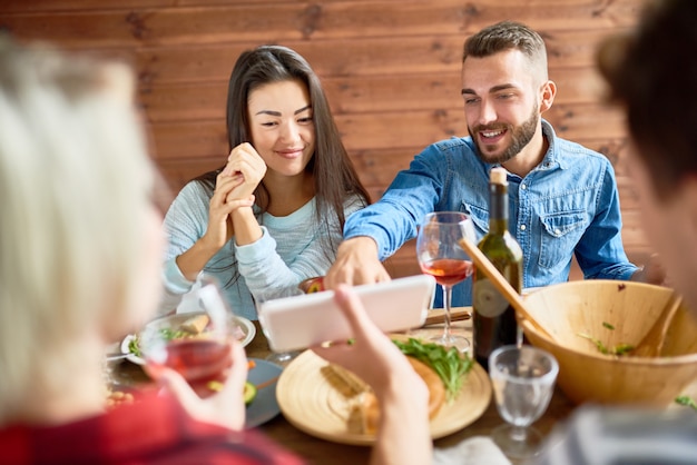 Young Couple Looking at Smartphone Photos