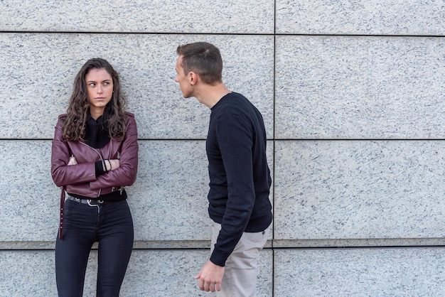 A young couple in love during an argument he tries to apologize she looks at him with anger expression of anger during a falling out between lovers