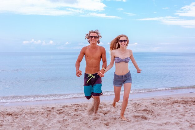 Young couple in love at beach and enjoying time being together, running on the beach