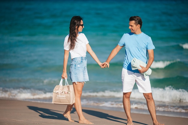 Young couple in love on the beach summer vacation Happy man and woman look at the sea