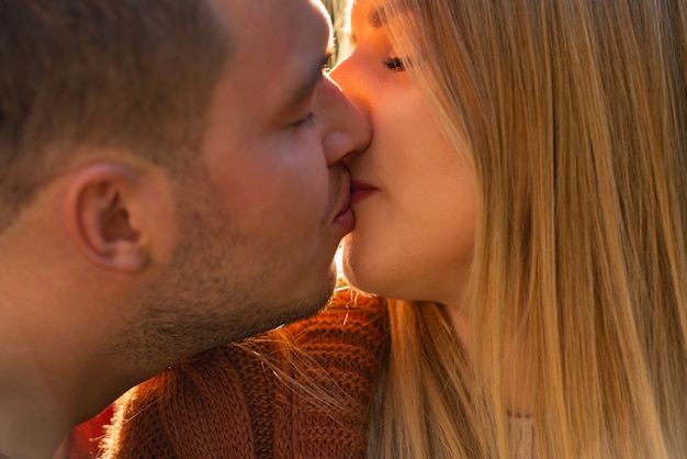 Photo young couple in love enjoying a romantic kiss in a close up cropped view of their faces in profile