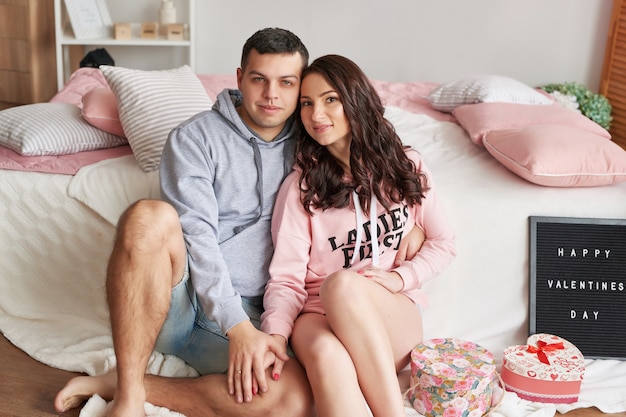 Young couple in love at home on bed celebrating Valentine's Day