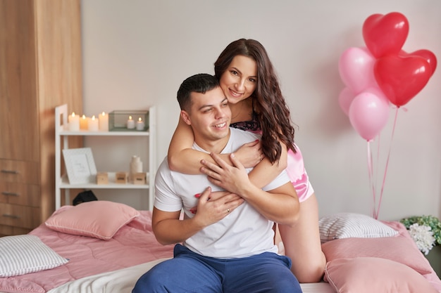 Young couple in love at home on bed celebrating Valentine's Day