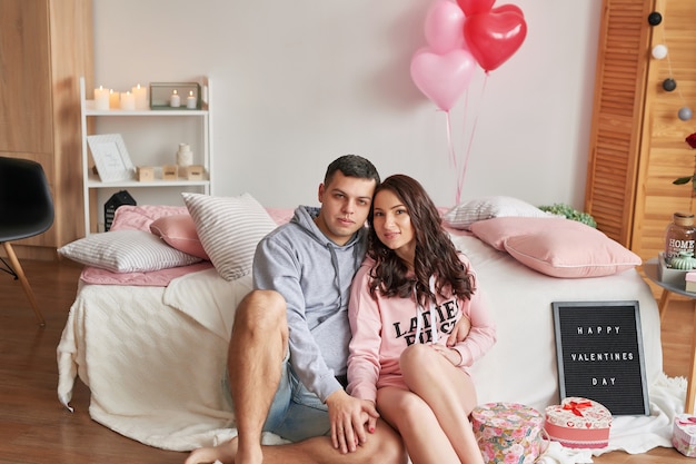 Young couple in love at home on bed celebrating Valentine's Day