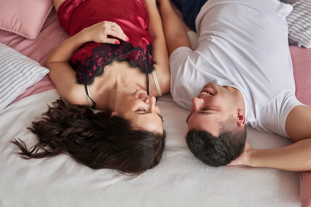 Young couple in love at home on bed celebrating Valentine's Day