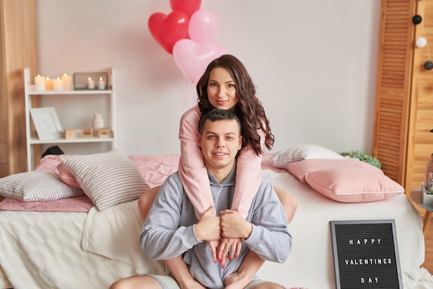 Young couple in love at home on bed celebrating Valentine's Day