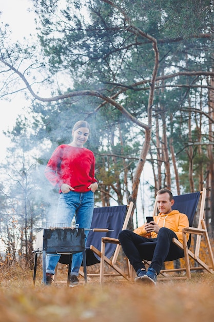 A young couple in love is grilling a barbecue in nature Family recreation in nature