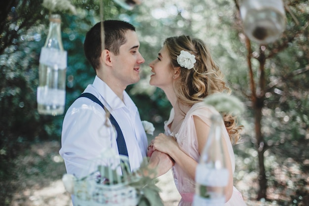 Young couple in love look at each other holding hands in nature in summer