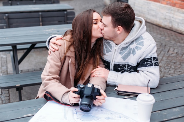 Young couple in love travels and kissing outdoor in cold winter weather