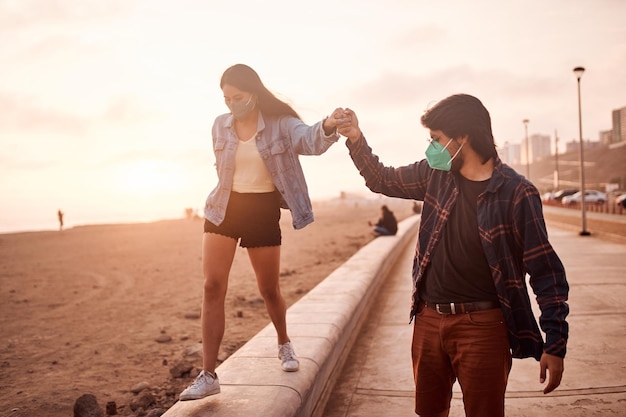 Young couple in love walk along the beach during a beautiful sunset