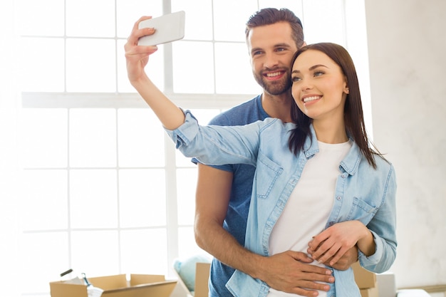 Young couple man and woman moving to a new apartment together relocation using digital device