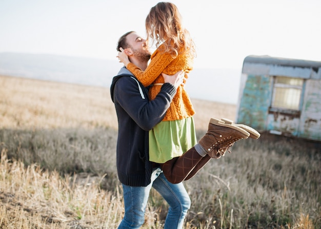 Young couple of man and woman outdoors, woman jumping in man's arms