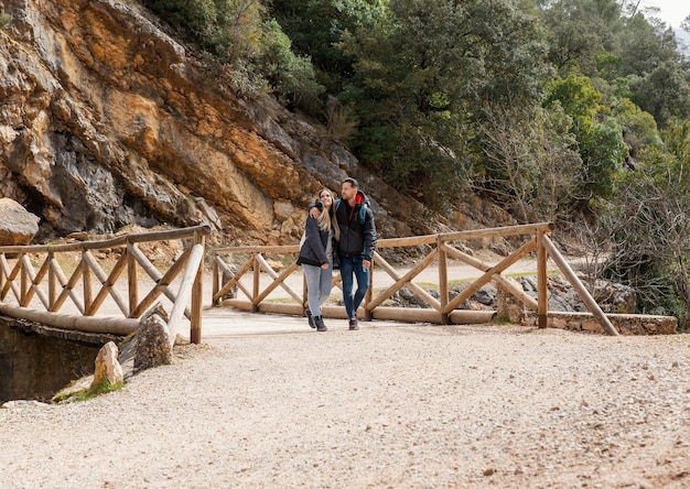 Young couple in nature sitting on bridge